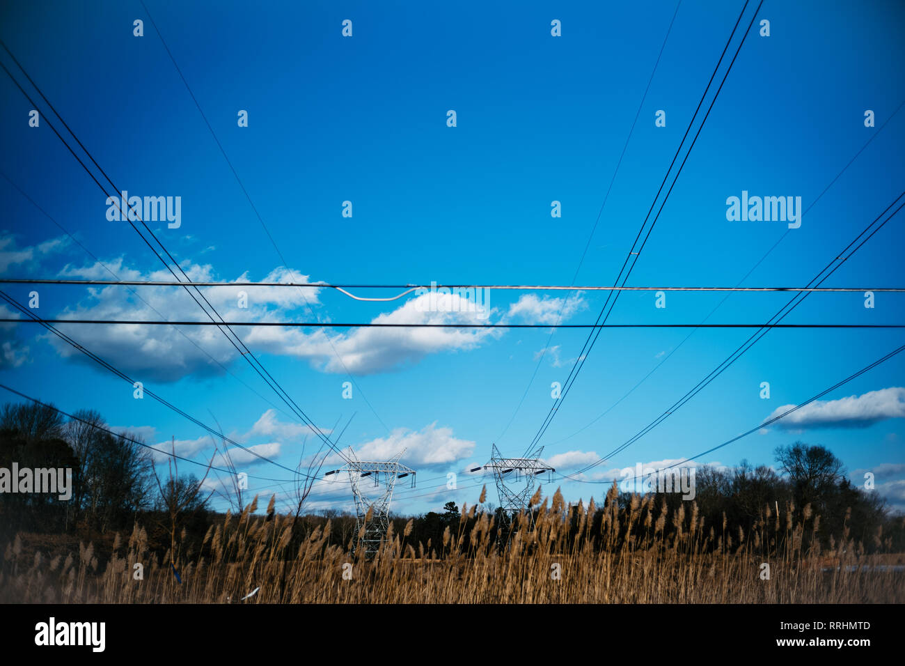 Electricity pylon and lines in countryside blue sky Stock Photo