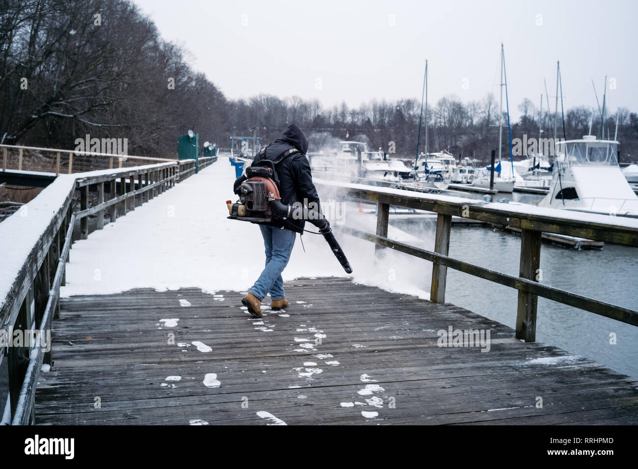 Frigid snow covered docks during winter at quiet east coast marina. Stock Photo