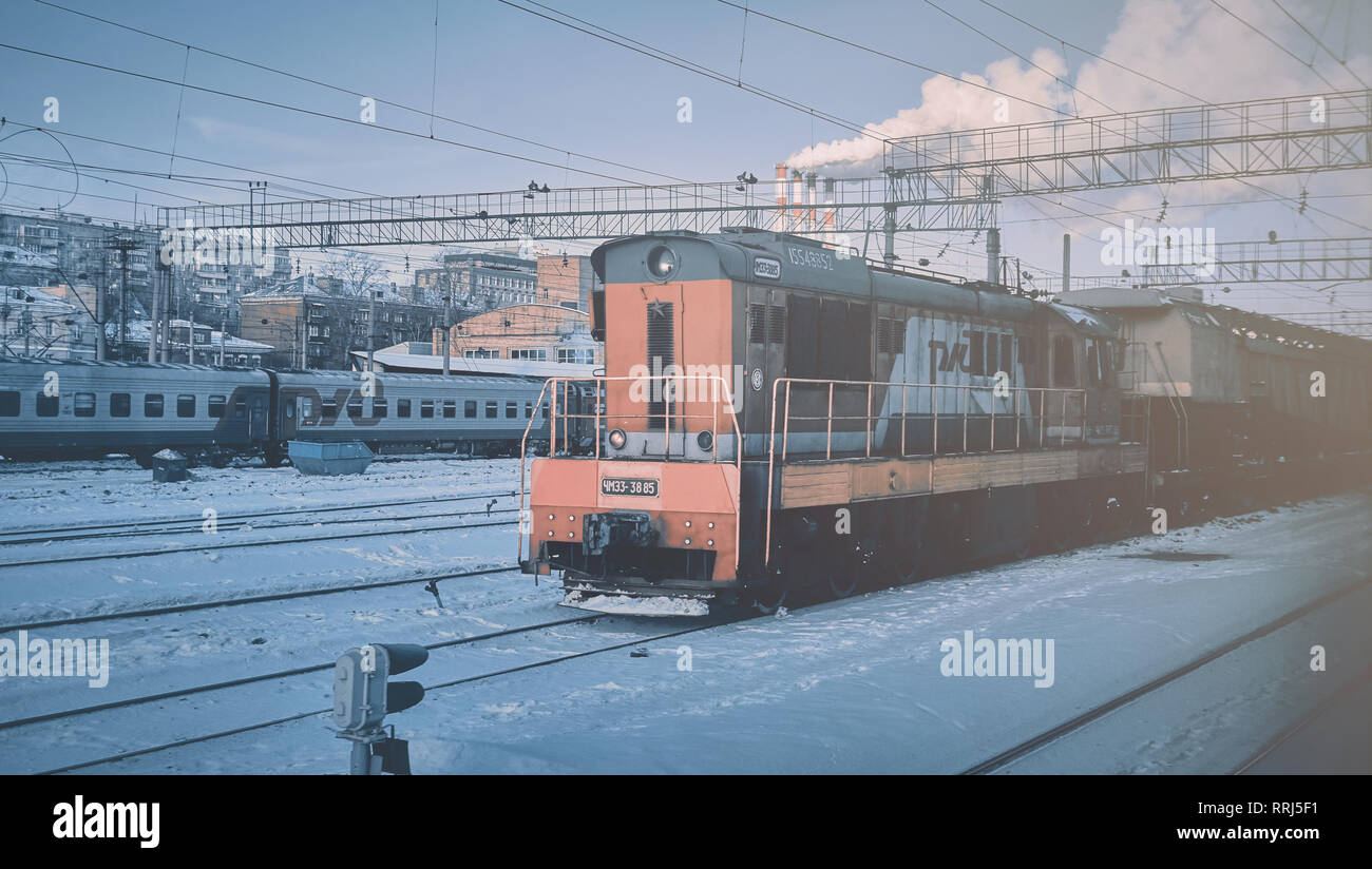 Moscow, Russia - Jan 2019: Locomotive russian RZD cargo company at the head of the freight train. Locomotive carries freight train past the railway st Stock Photo