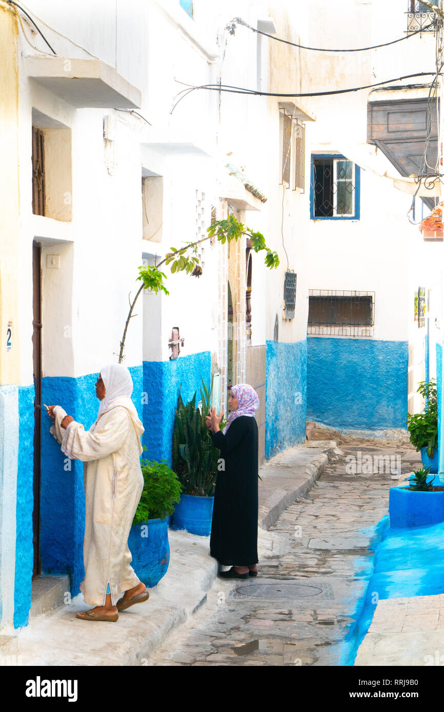 Two woman in local dress at neighbouring front doors, Kasbah des Oudaias, UNESCO World Heritage Site, Rabat, Morocco, North Africa, Africa Stock Photo