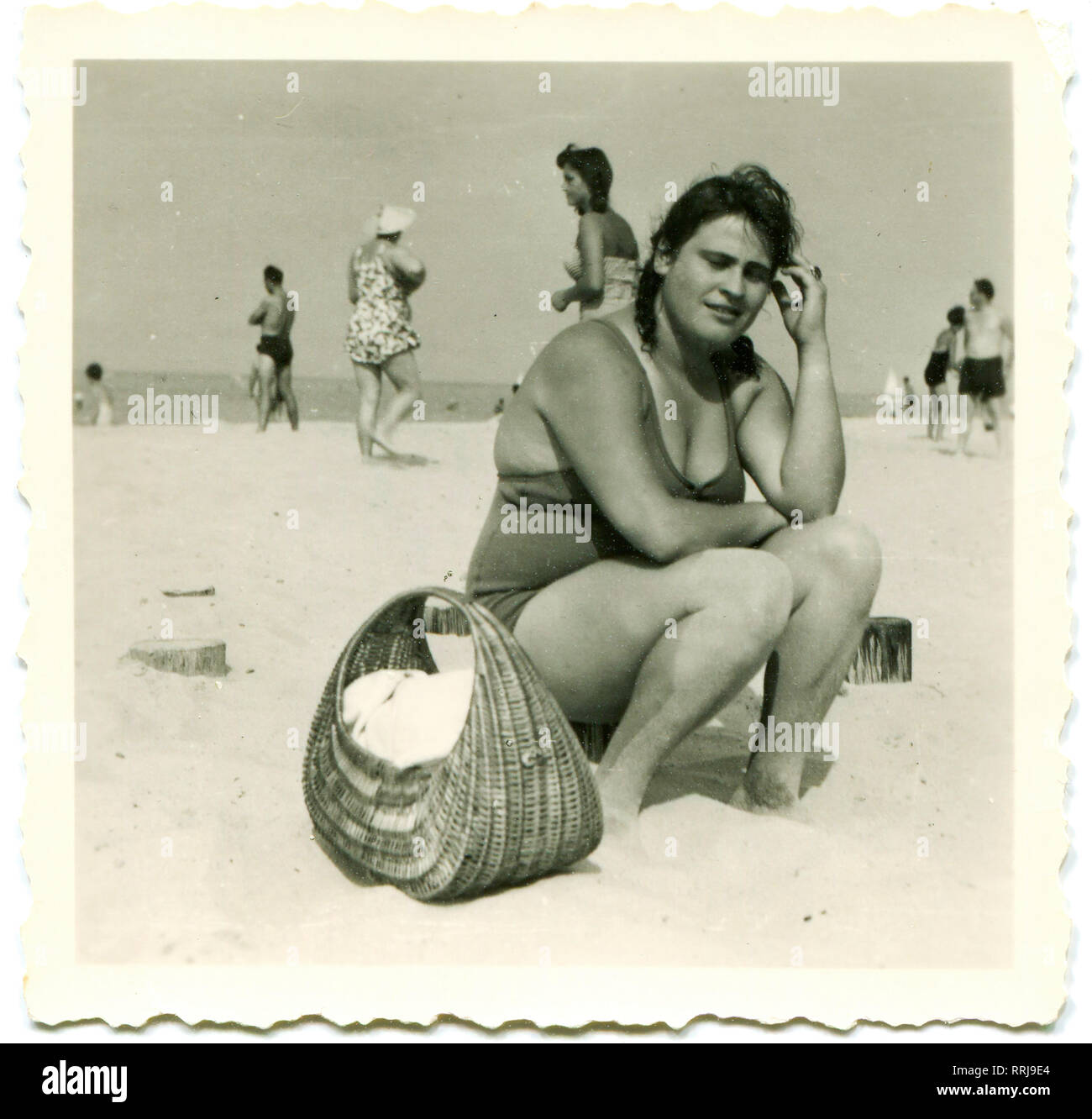 Germany .1940s . Young plump woman on the beach. Near the basket of wicker. Stock Photo