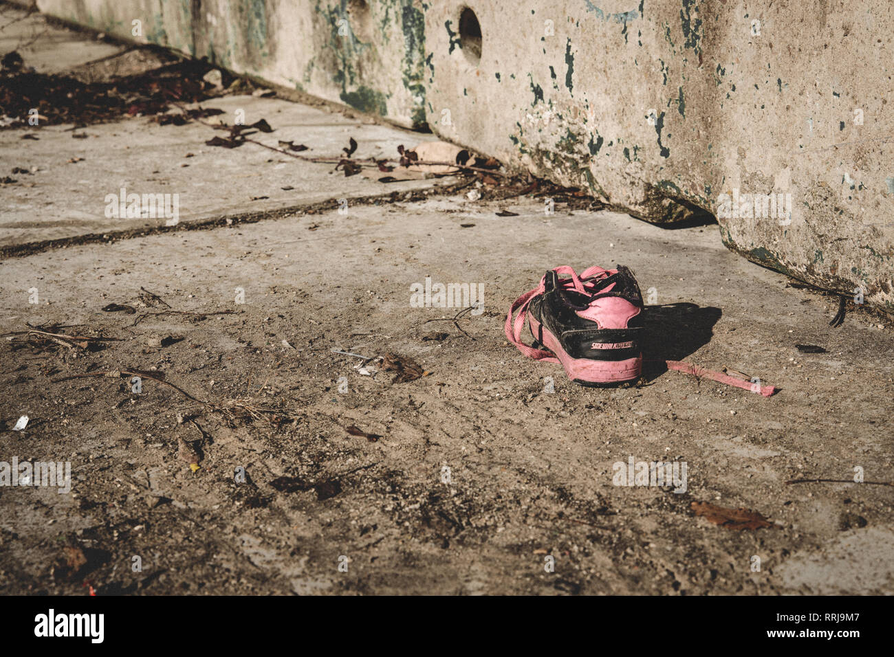 Abandoned shoe in run down derelict street Stock Photo