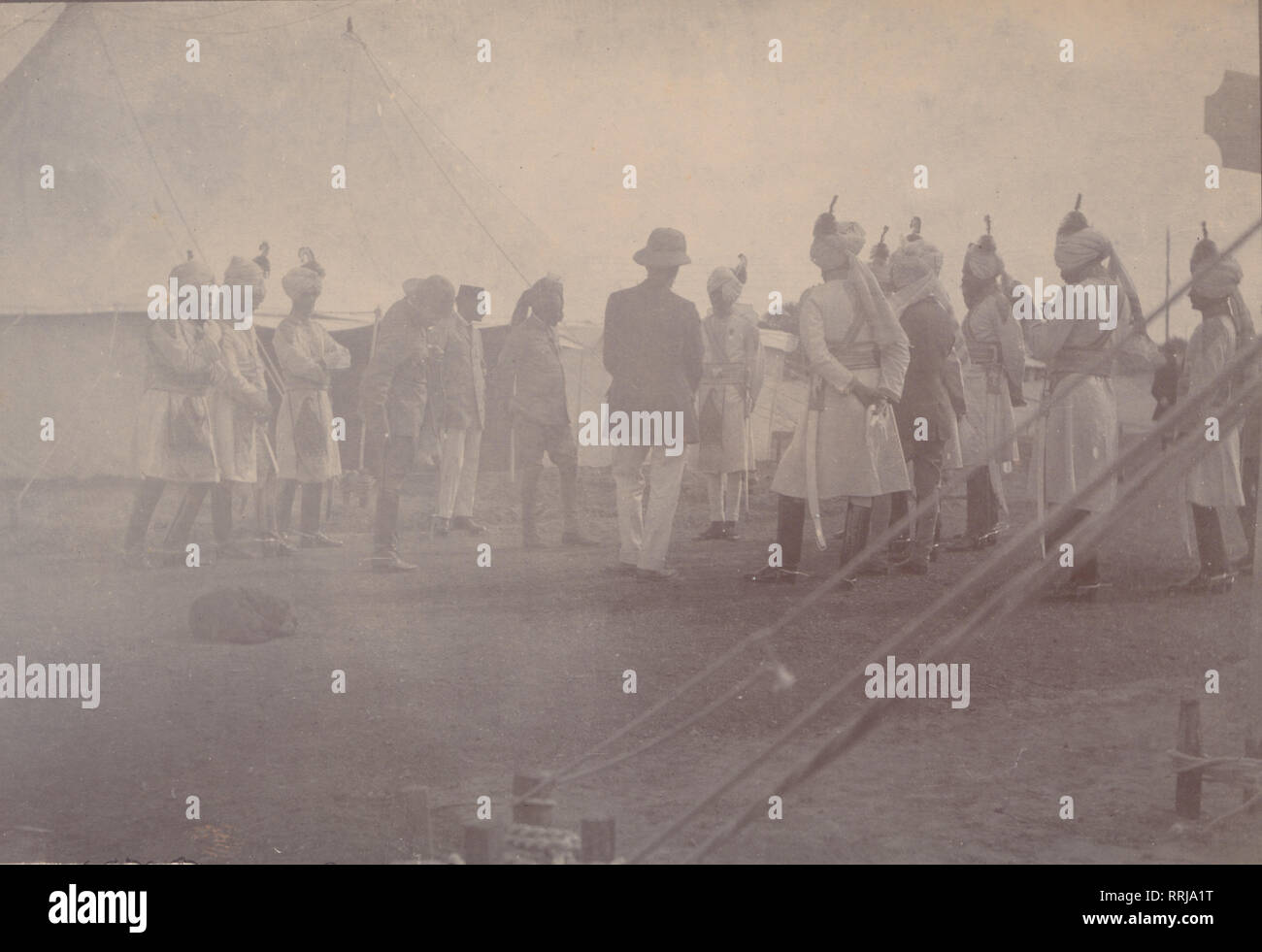 Vintage Photographic Postcard Showing a Group of Sikh Soldiers Having a Meeting Inside an Army Camp. Location Unknown. Stock Photo