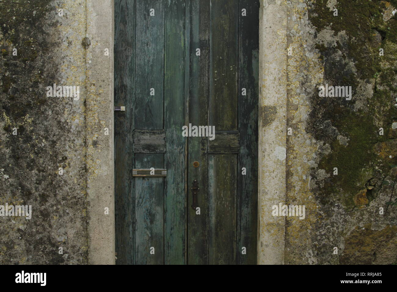 Old green/teal weather door with lichen covered concrete walls, Sintra, Portugal Stock Photo