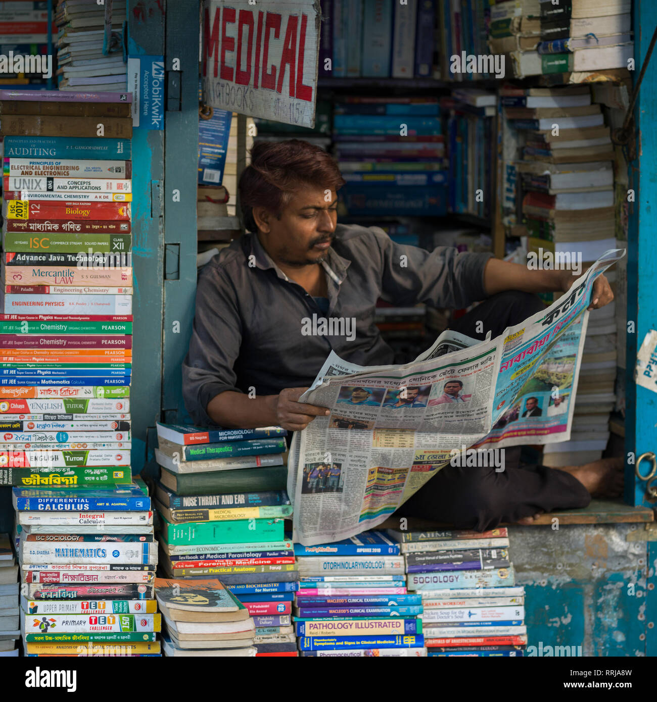 Man reading newspaper at stationery shop, Kolkata, West Bengal, India Stock Photo