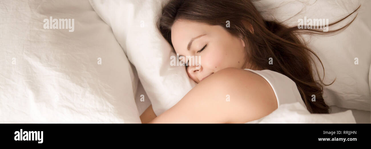 Above panoramic view young woman sleeping in bed hugging pillow Stock Photo