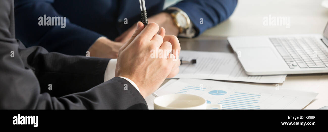 Horizontal cropped image businessmen brainstorming using charts shown at papers Stock Photo