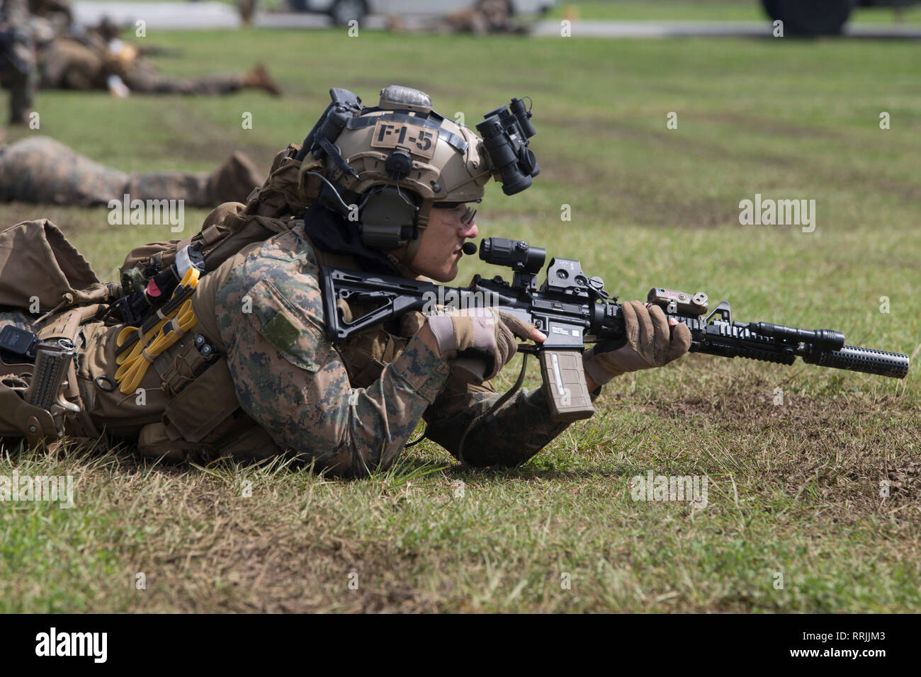A Marine with the 31st Marine Expeditionary Unit’s Maritime Raid Force posts security during a simulated raid at Camp Hansen, Okinawa, Japan, Feb. 25, 2019. The 31st MEU, in a groundbreaking command and control exercise, is completing split operations across a large swath of the Indo-Pacific region encompassing at least four geographic locations – Okinawa, Japan; aboard the dock landing ship USS Ashland (LSD 48) in the South China Sea; aboard the amphibious transport dock USS Green Bay (LPD 20) in the Gulf of Thailand; and other undisclosed locations. This is the first time any Marine expediti Stock Photo