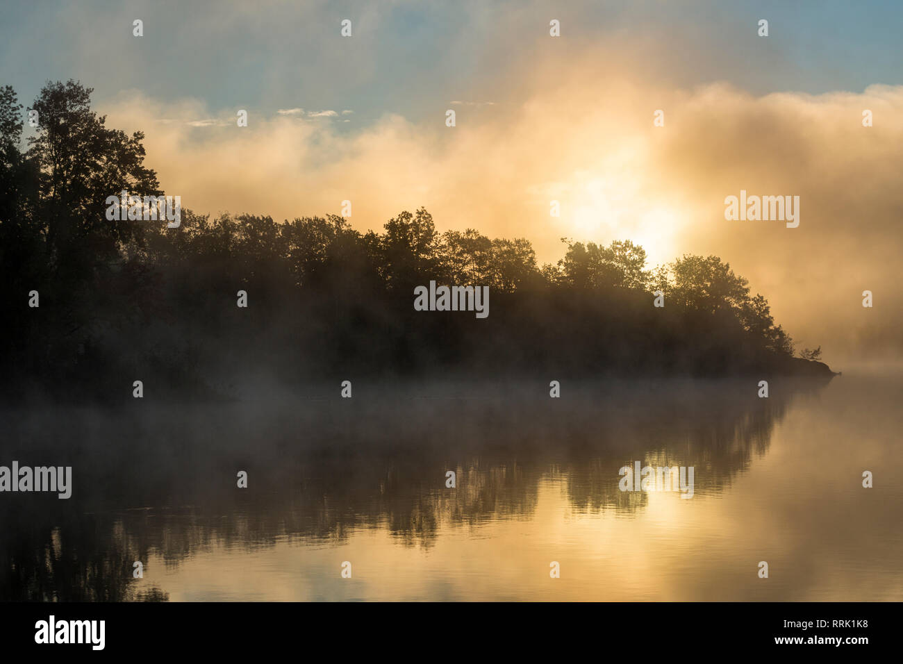 Sun rising behind fog bank, Simon Lake, Naughton, Ontario, Canada Stock Photo