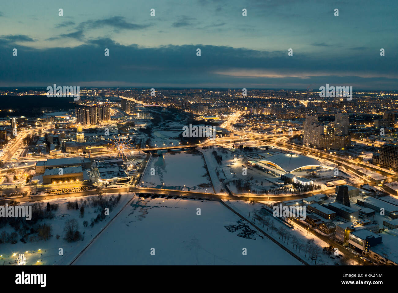 Aerial drone panorama; beautiful view Chelyabinsk city with illuminated streets and bridges at night; winter evening South Ural capital; industrial an Stock Photo