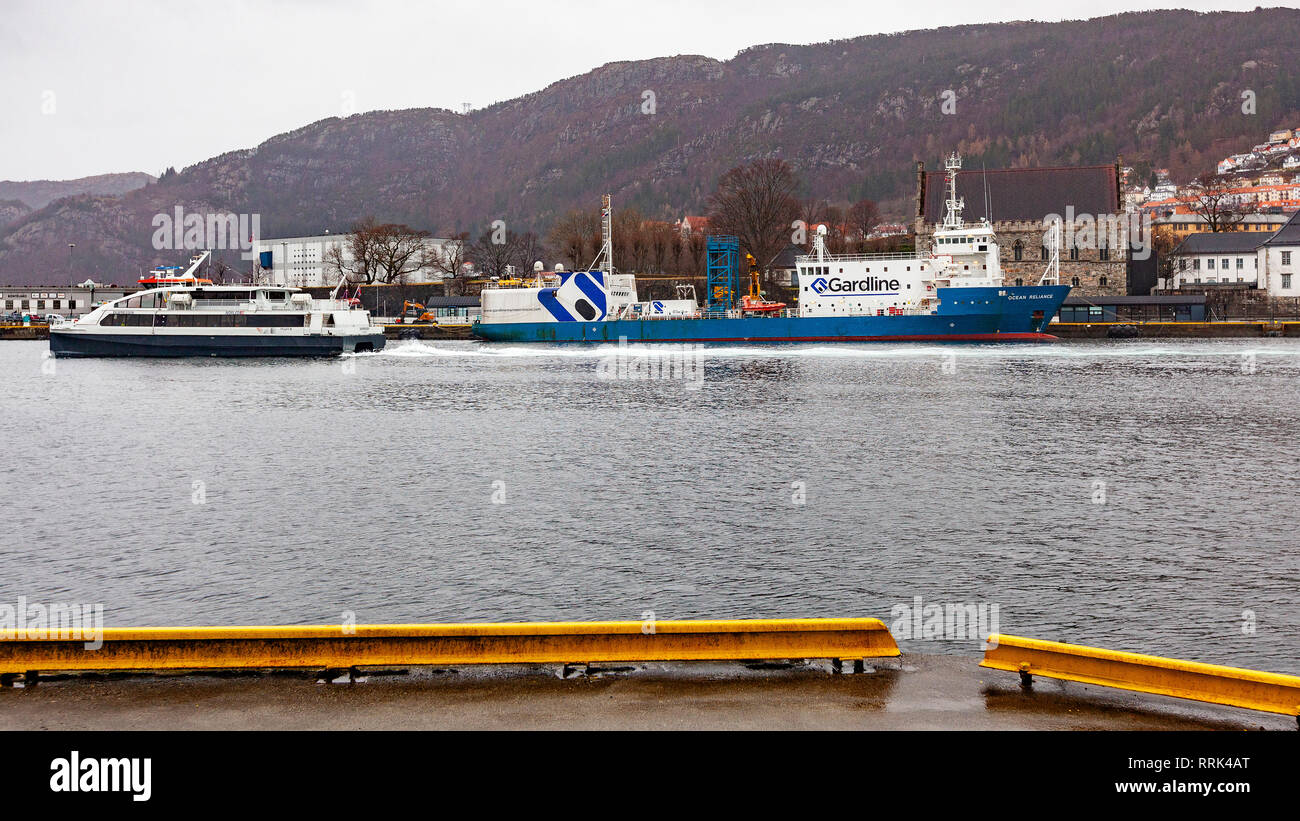 Ocean research / survey vessel Ocean Reliance in the port of Bergen, Norway. High speed passenger catamaran Ekspressen passing on it's way out from th Stock Photo