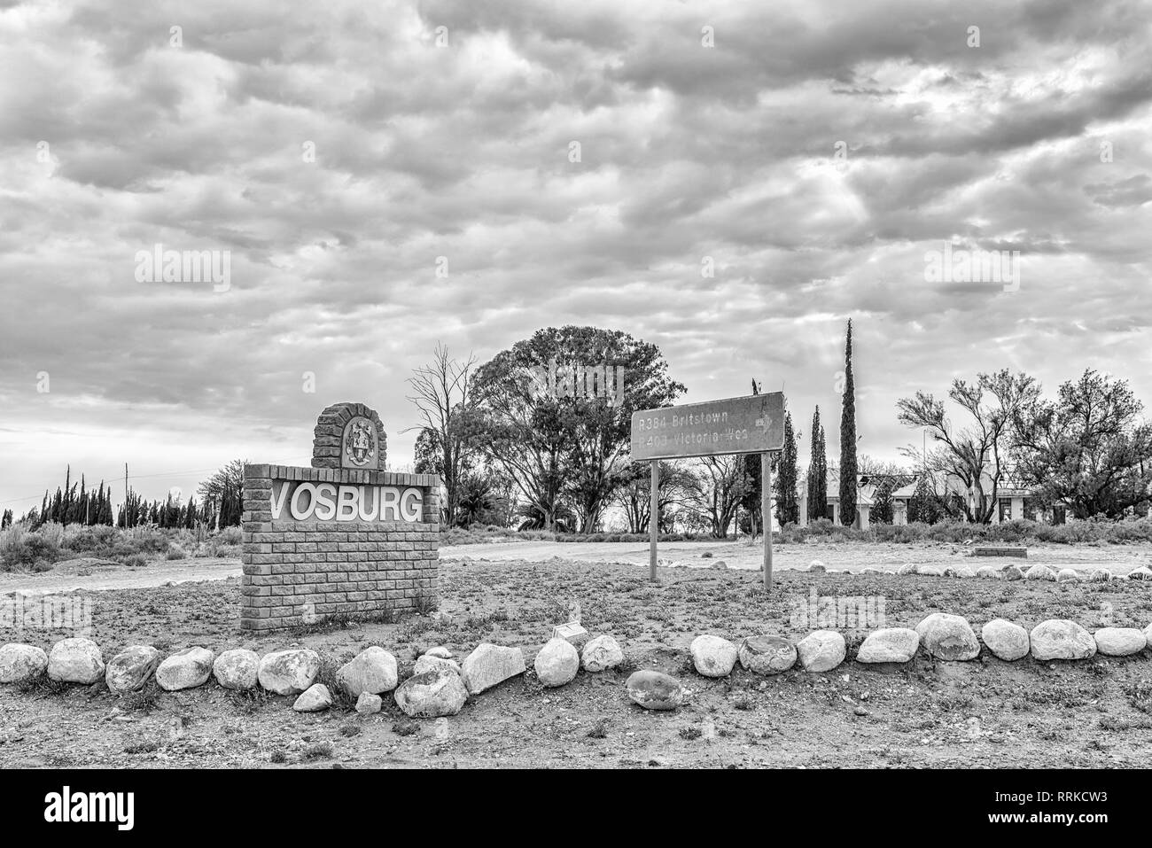 VOSBURG, SOUTH AFRICA, SEPTEMBER 1, 2018: A name board and directional sign at the entrance to Vosburg in the Northern Cape Province. Monochrome Stock Photo