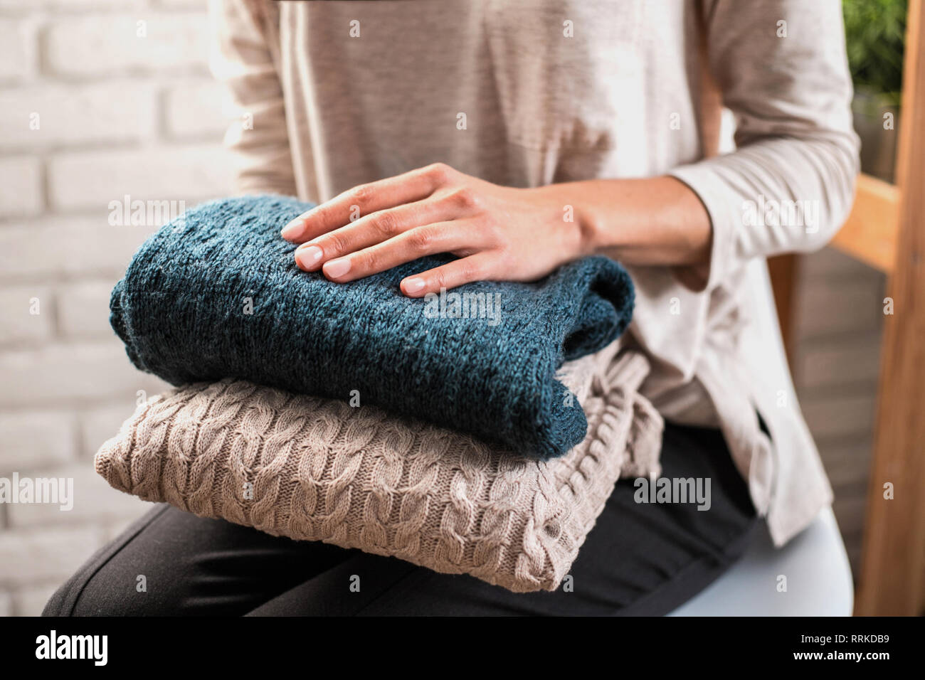 Woman's hands holding knitted clothes. Close up. Stock Photo