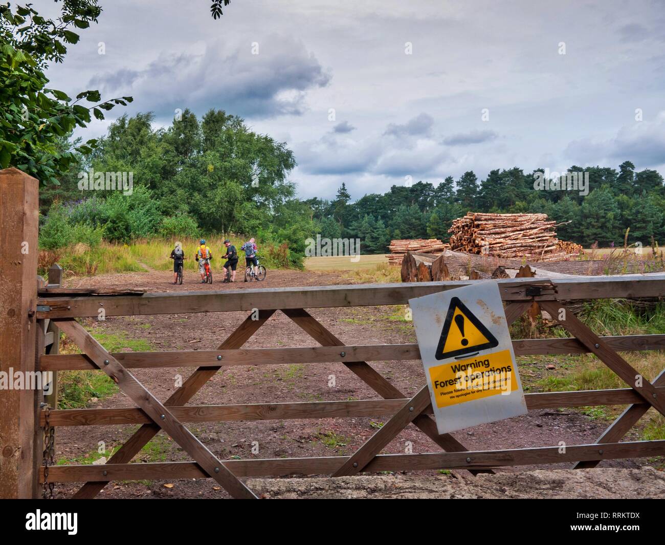 Mountain bikers ignore signs warning of forest operations in the surrounding area. Stock Photo