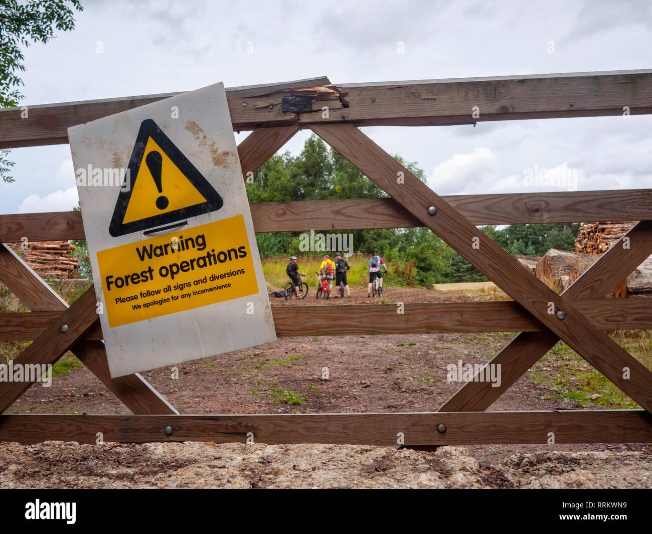 Mountain bikers ignore signs warning of forest operations in the surrounding area. Stock Photo