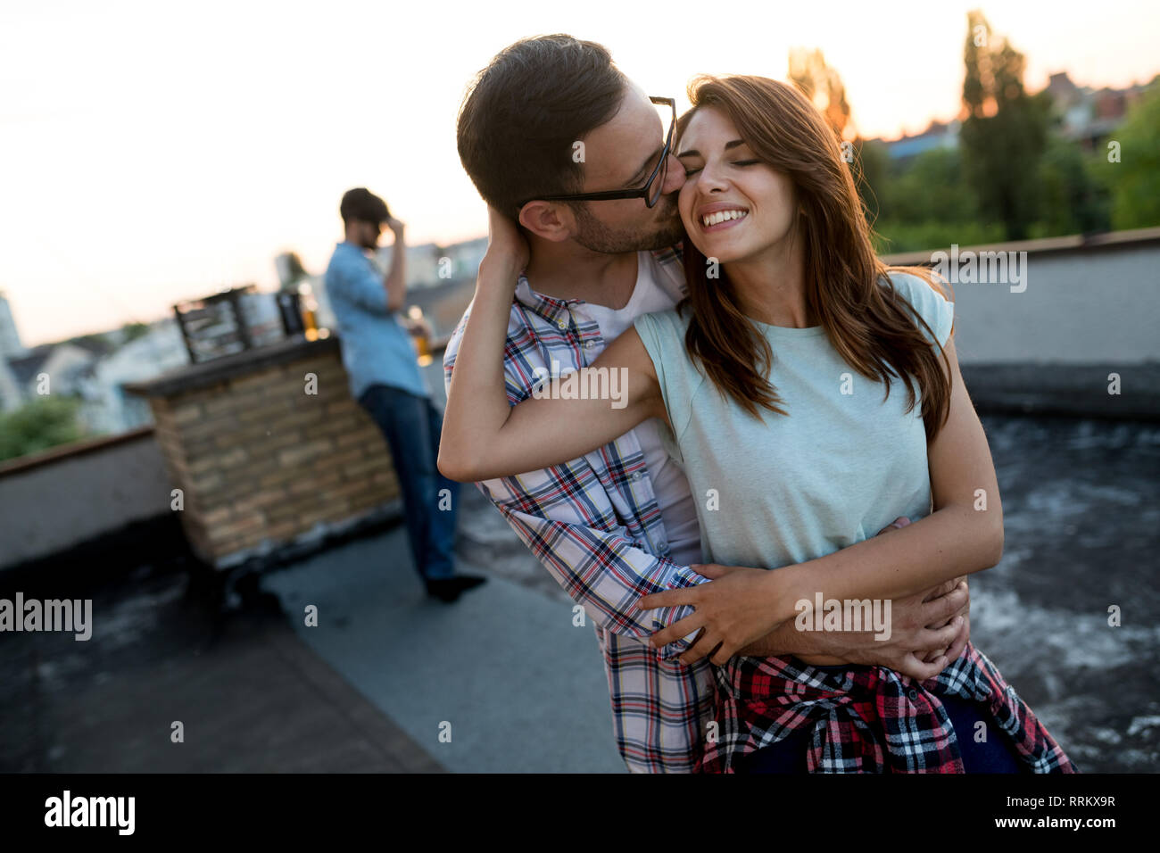 Couple in love enjoying in sunset in a terrace Stock Photo
