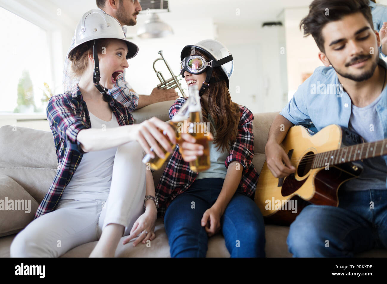 Group of friends playing guitar and partying at home Stock Photo