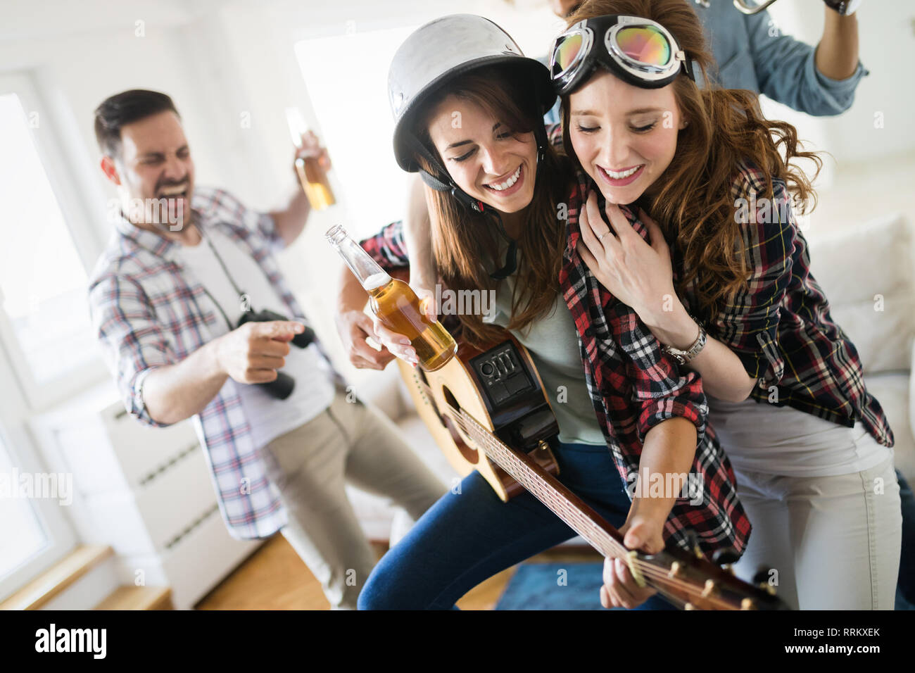 Friends having fun and partying in house and playing music Stock Photo