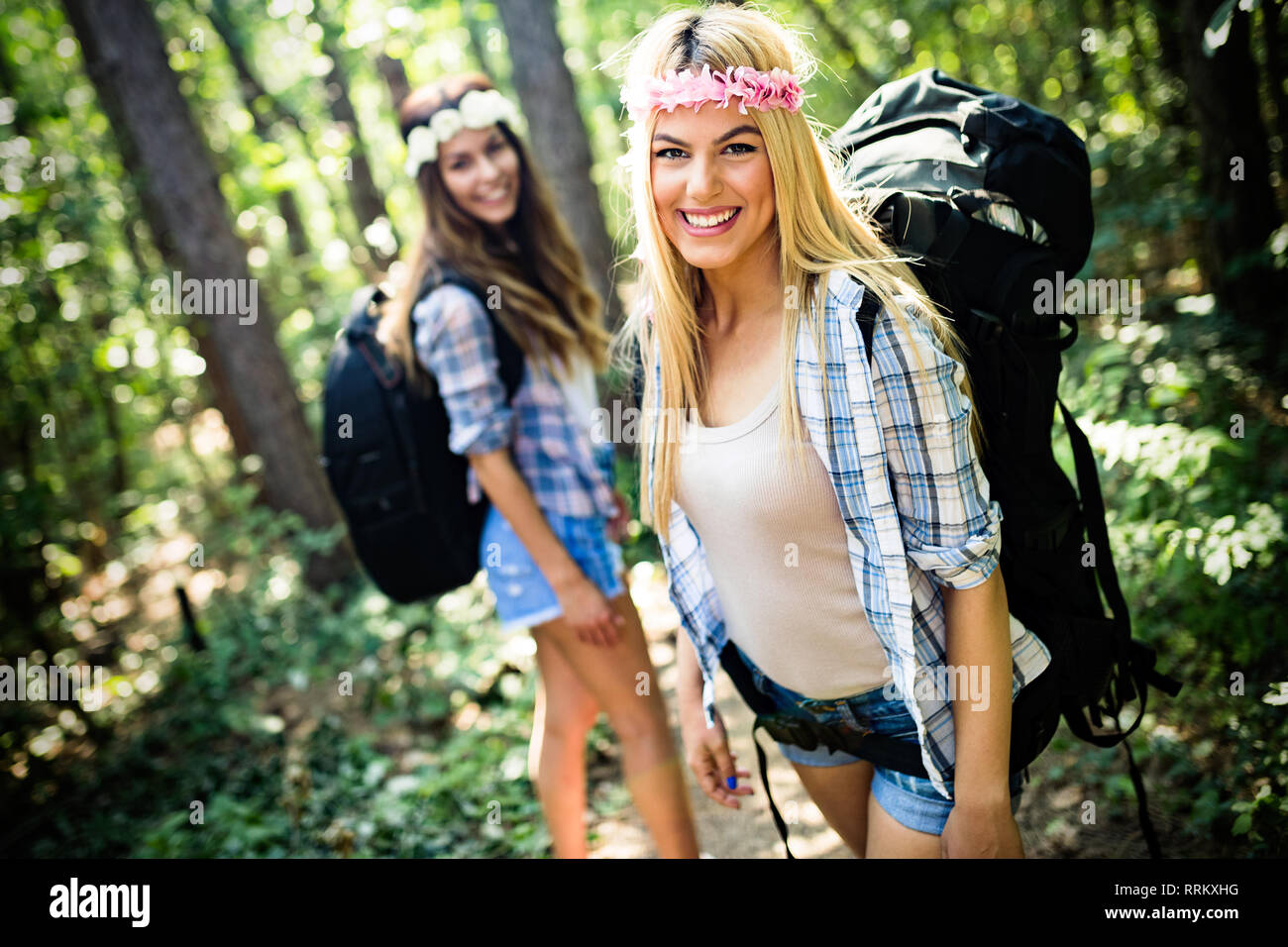 Adventure, travel, tourism, hike and people concept. Happy woman walking with backpacks in woods Stock Photo