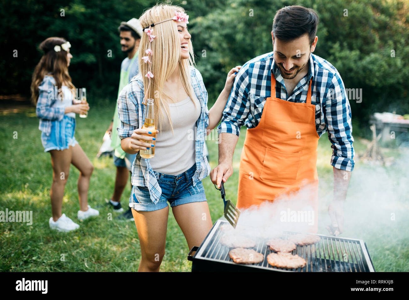 Group of happy friends having barbecue party in forest Stock Photo - Alamy