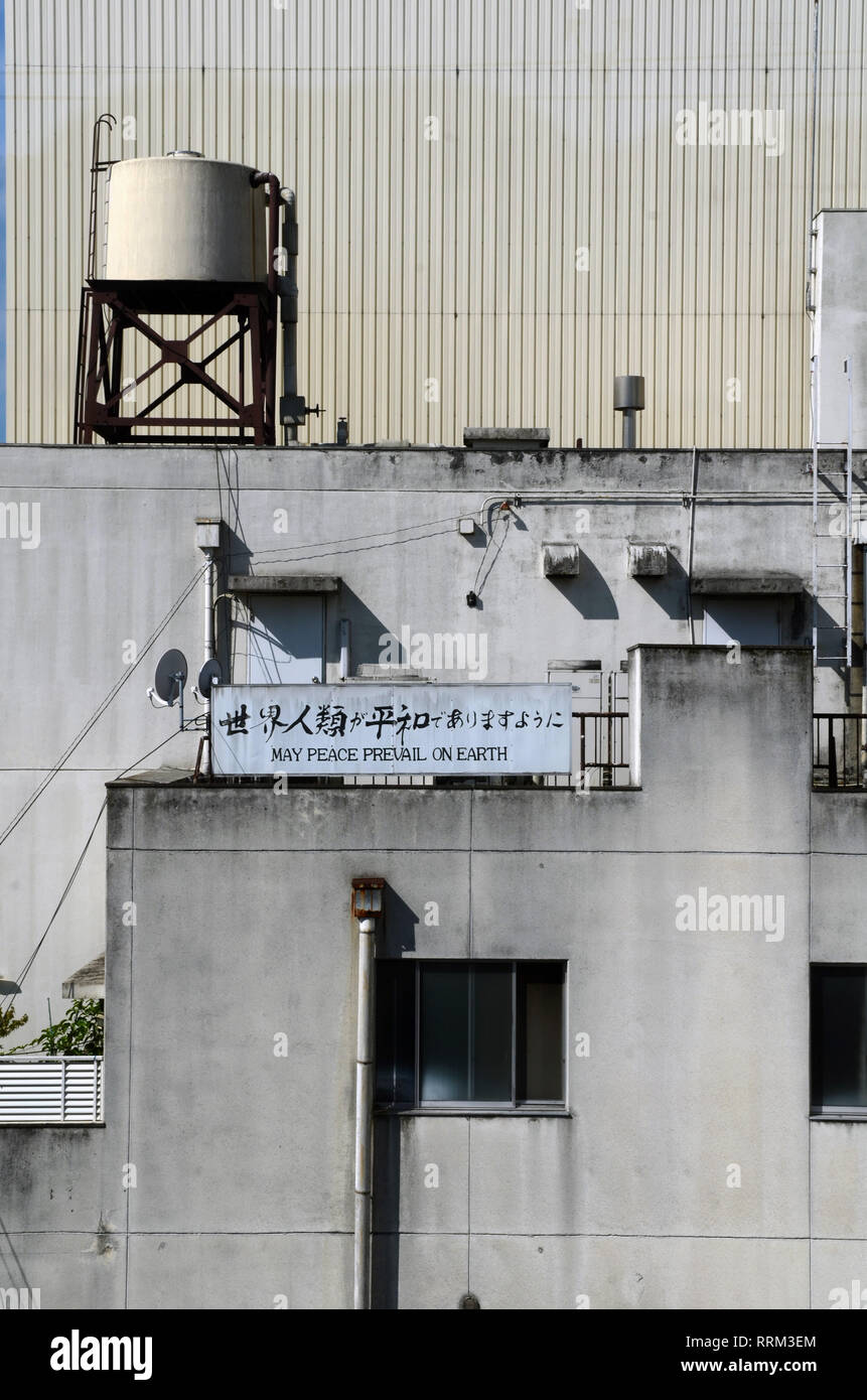 Sign on building reads "May peace prevail on earth", Tokyo Stock Photo
