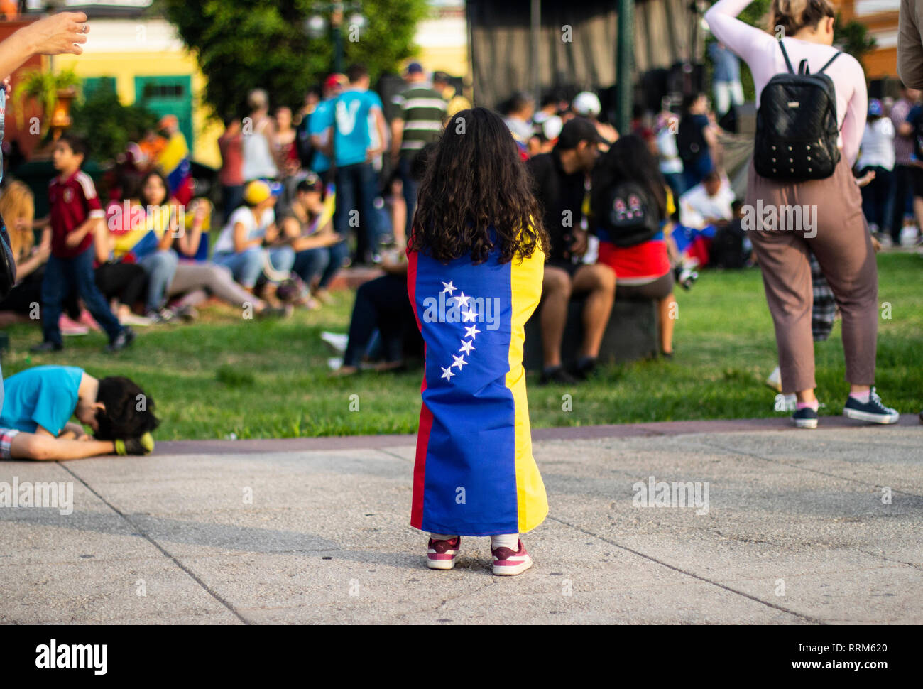 Lima, Lima / Peru - February 2 2019: Venezuelan young little girl wrapped around a flag at protest against Nicolas Maduro Stock Photo