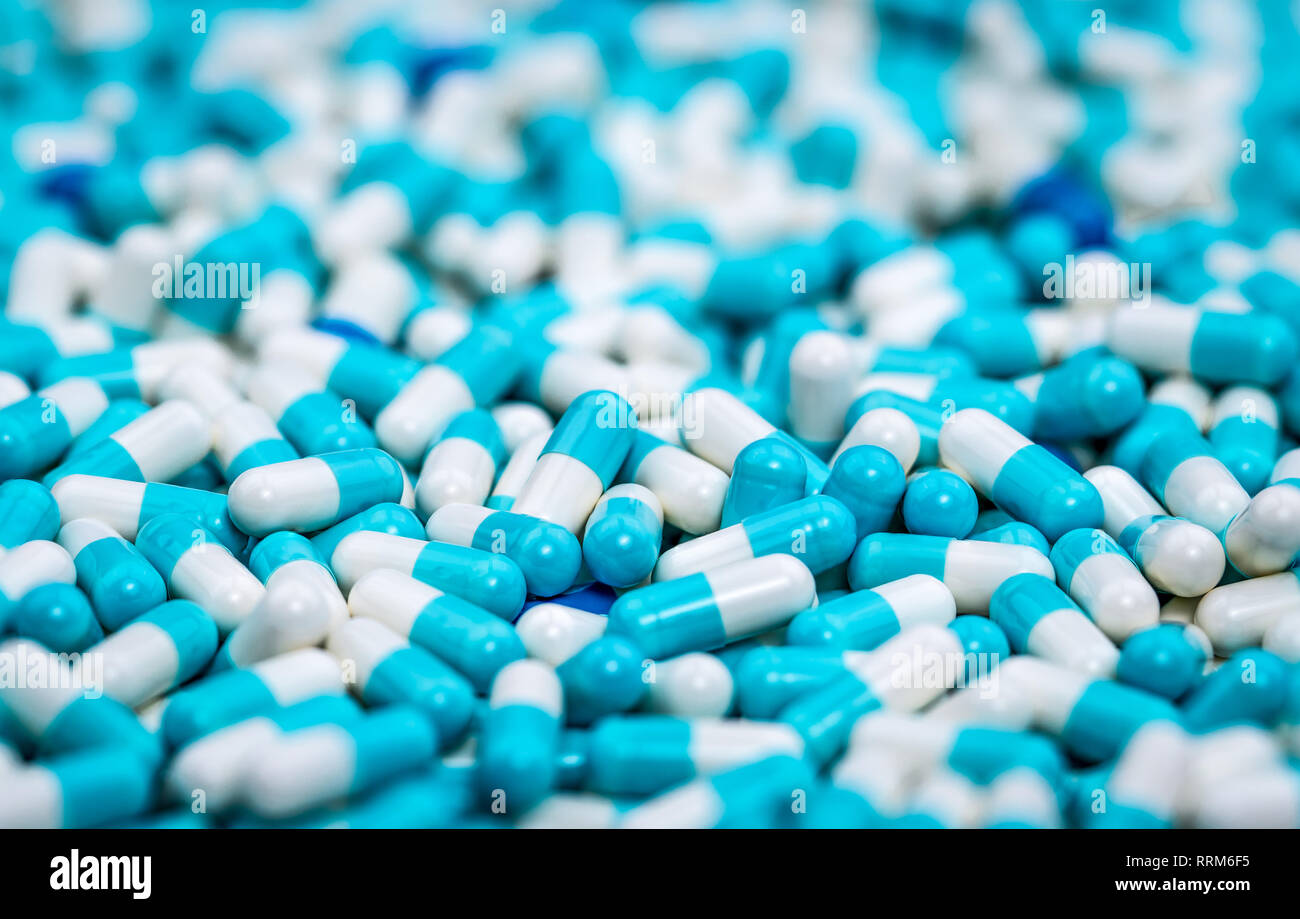 Selective focus on pile of blue and white antibiotic capsule pill. Pharmaceutical production. Global healthcare. Antibiotics drug resistance. Antimicr Stock Photo