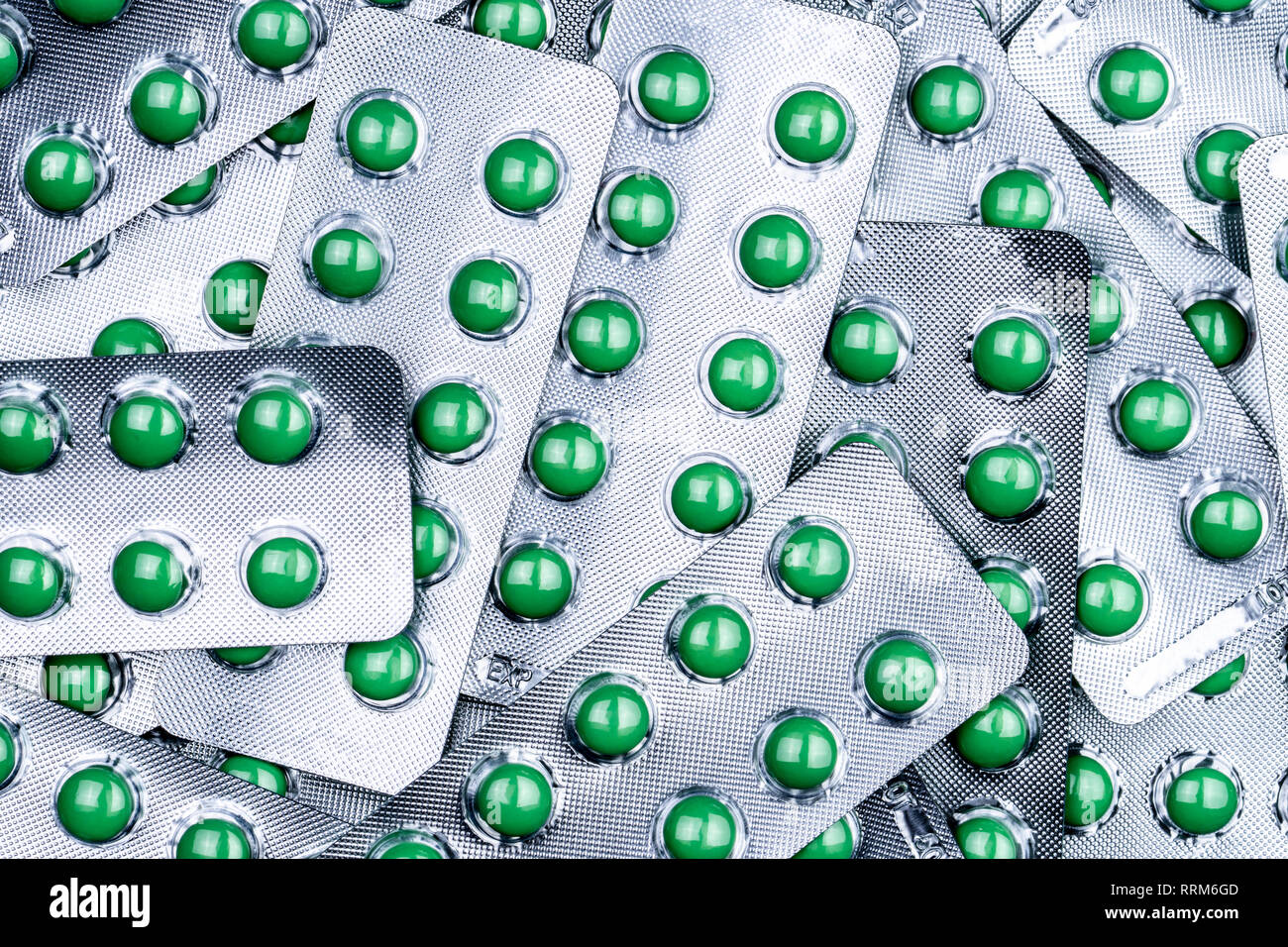 Closeup pile of round green sugar coated tablet pill in blister pack. Combine pill for relief cough. Pharmaceutical product. Pharmaceutical industry.  Stock Photo