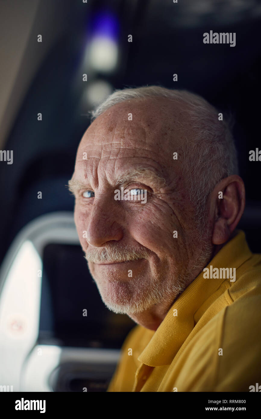 Friendly senior male smiling while traveling on airplane Stock Photo