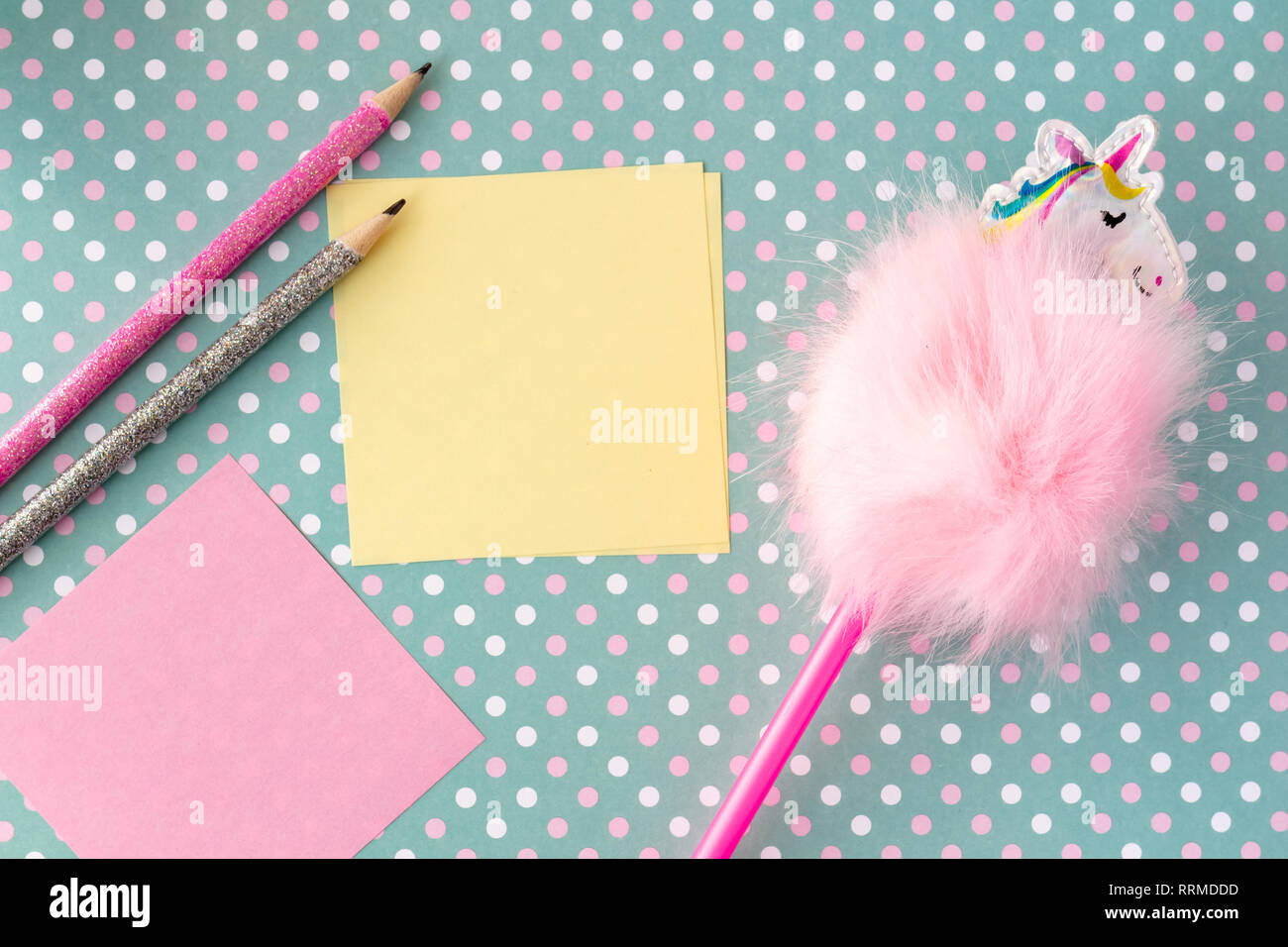 Colorful funny pencils with memo notes on dotted green background. Stock Photo