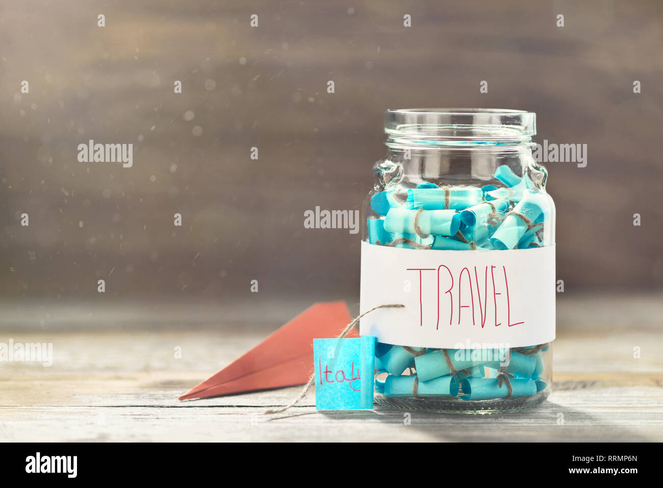 Glass jar with list of countries to visit and paper airplane. Creative