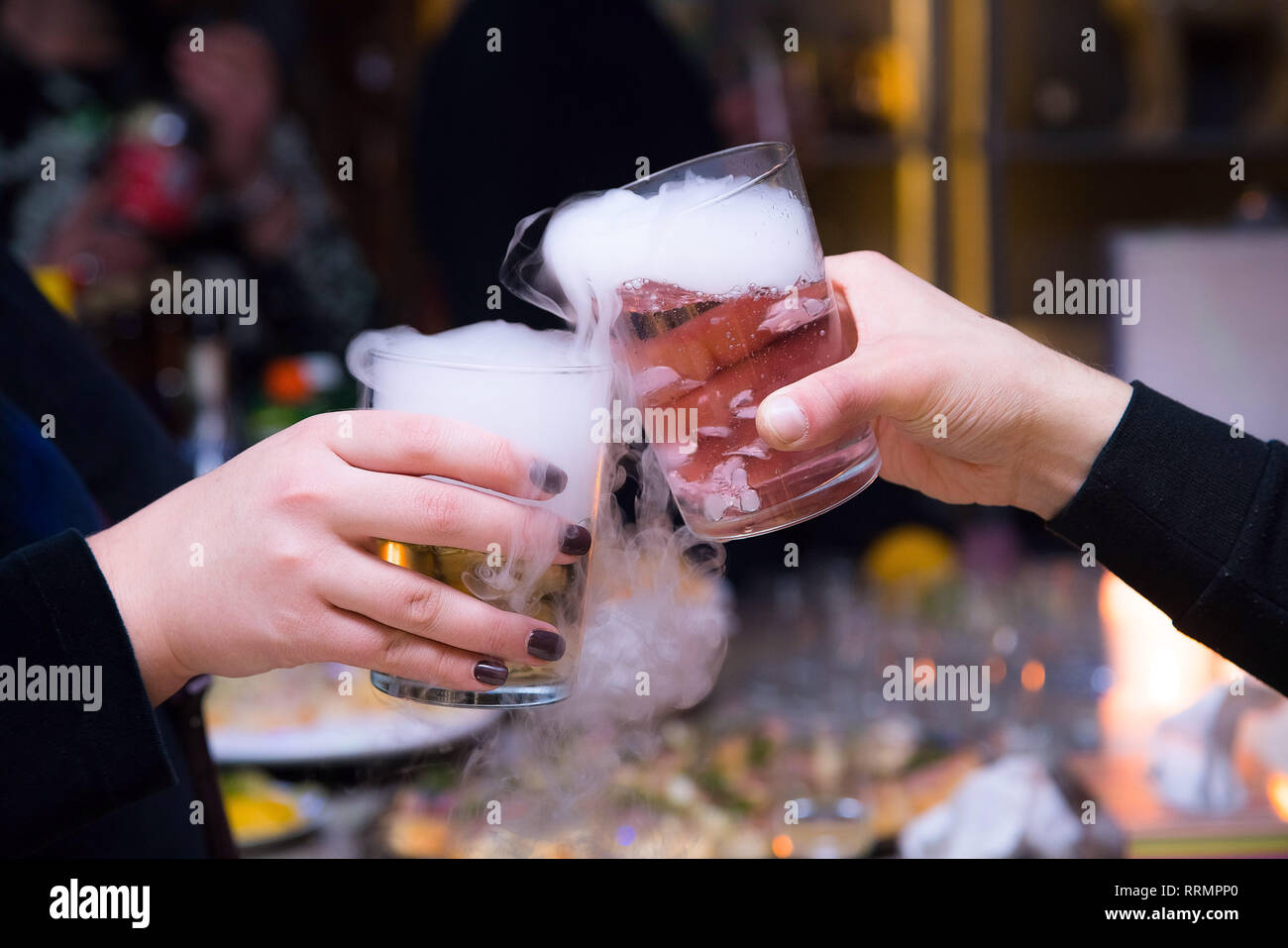 Beautiful couple holding dry ice cocktails at the party. Purple cocktail  drink with ice vapor at the club, celebration Stock Photo - Alamy