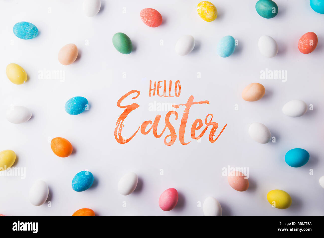 Hello Easter phrase and eggs on a white background. Studio shot. Flat lay. Stock Photo