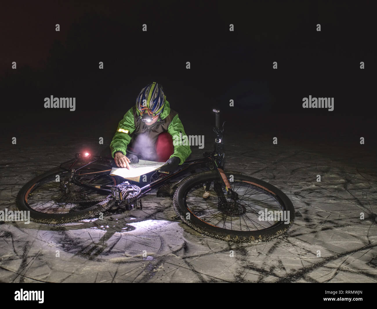 Winter night extreme bike racer control navigation. Fat tyre bike in
