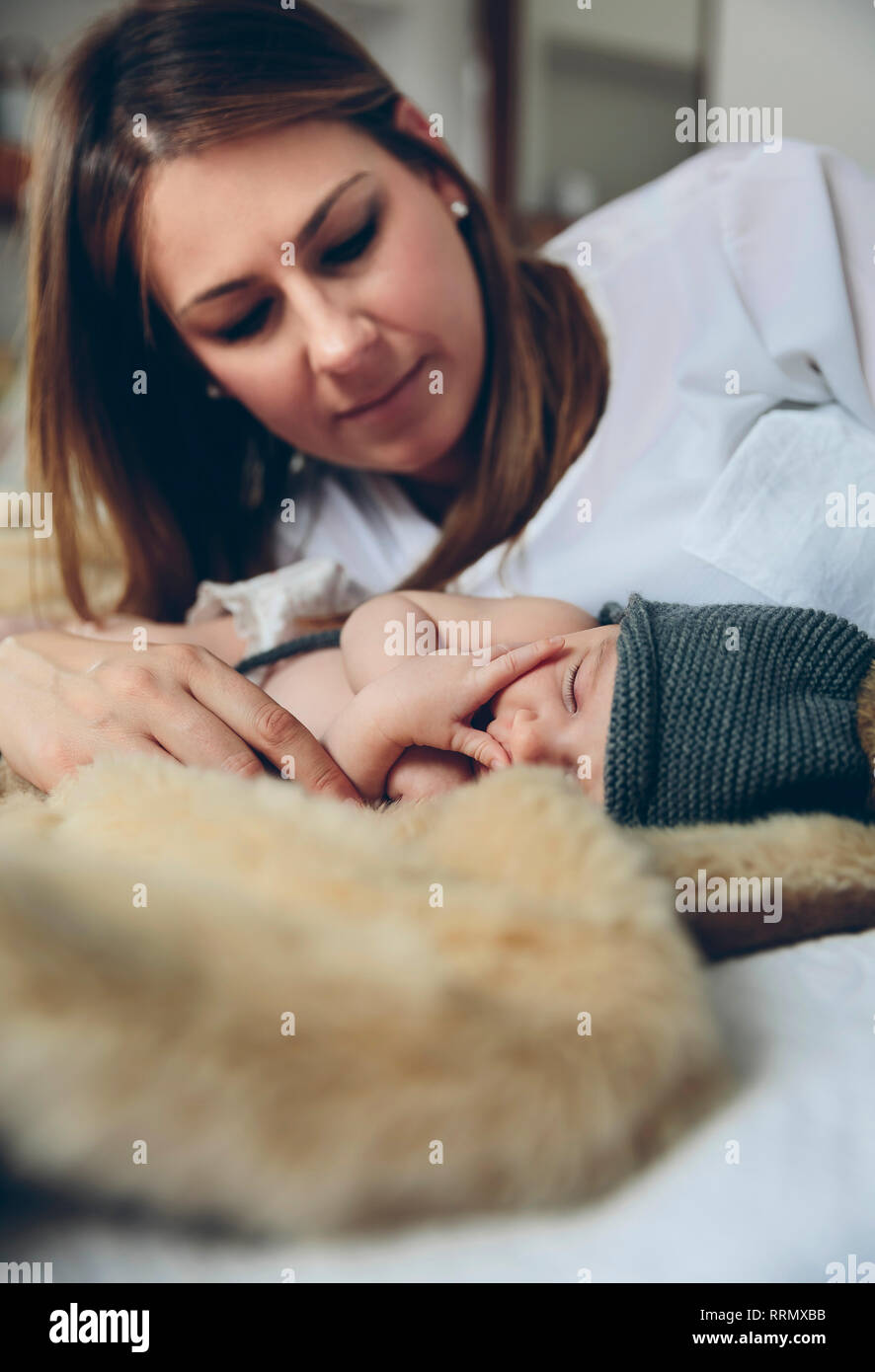 Baby sleeping on a blanket while her mother looks Stock Photo Alamy