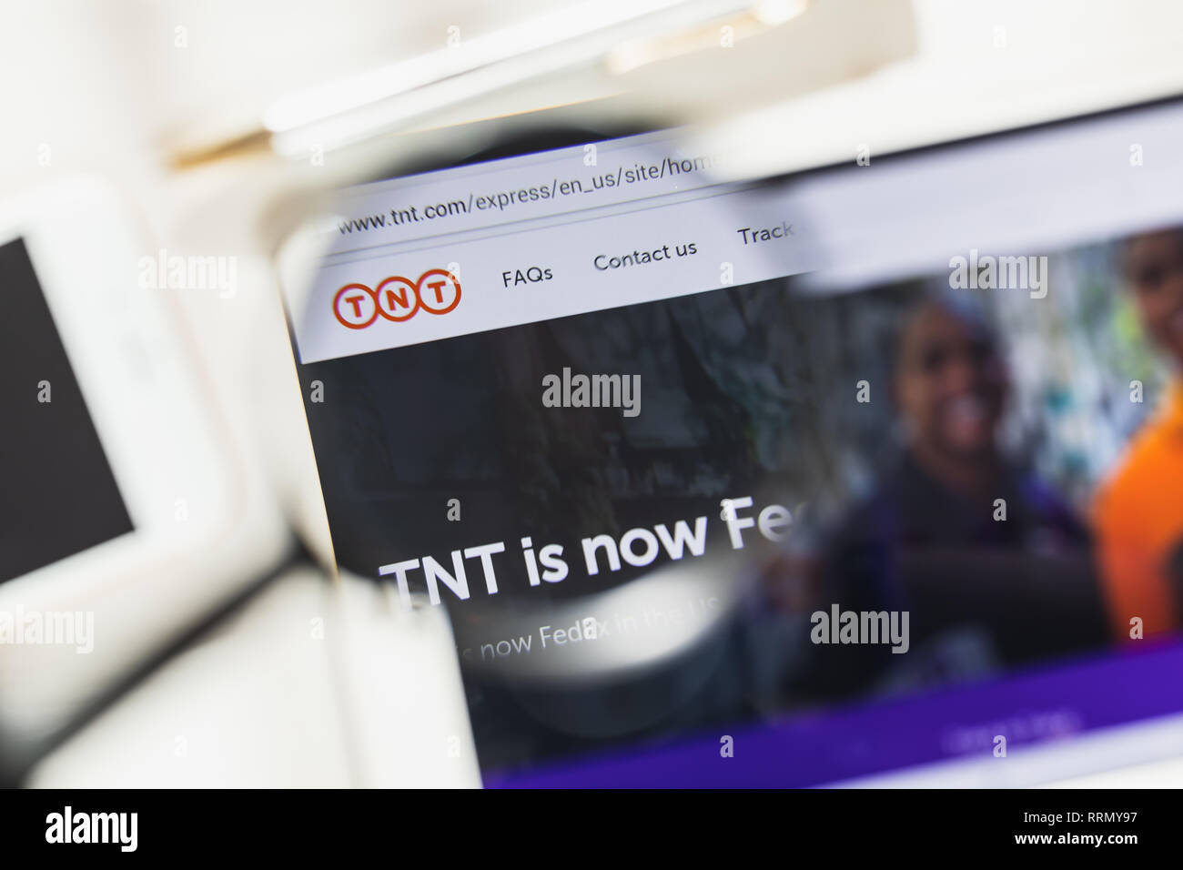Washington, D.C., USA - 27 February 2019: TNT Express official website homepage under magnifying glass. Concept Moody's Corporation logo visible Stock Photo