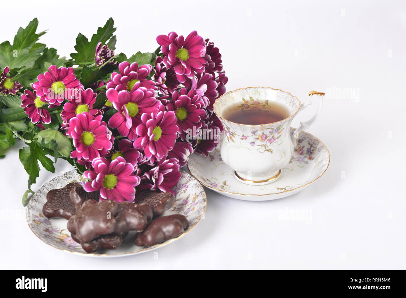 Table setting, flower bouquet, tea and cookies Stock Photo
