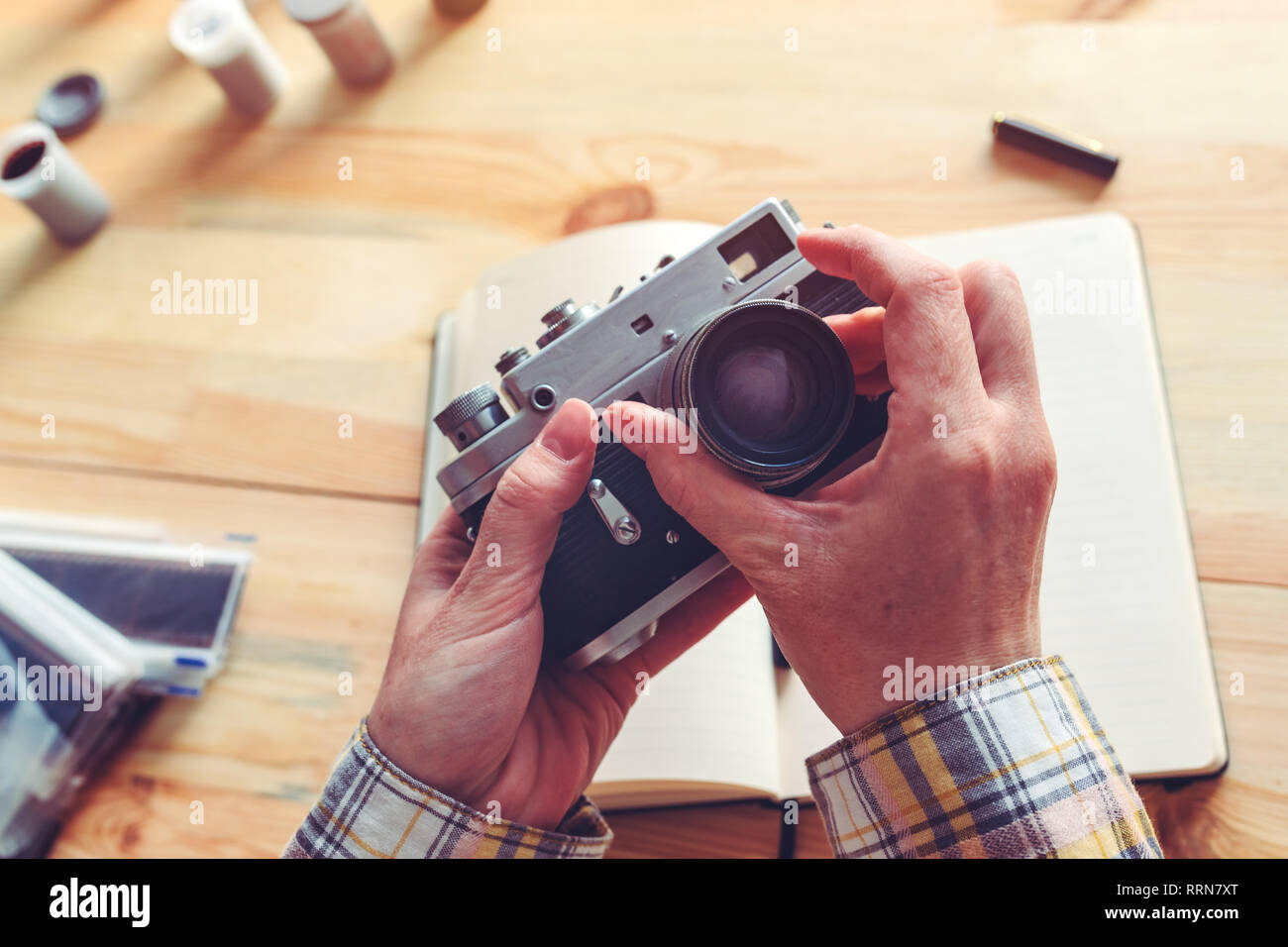 Photographer changing lens on vintage film photography camera in studio, selective focus Stock Photo