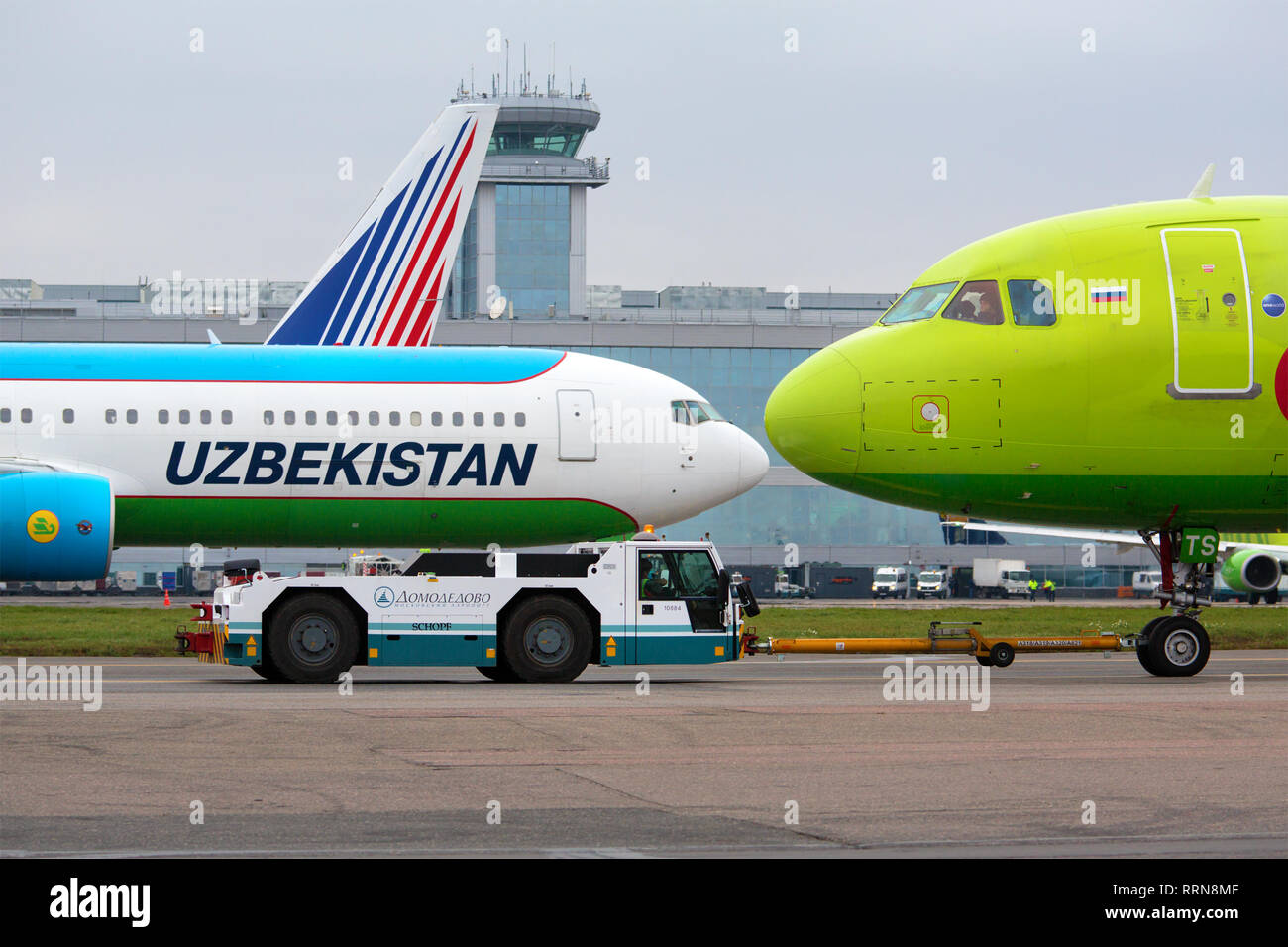 Uzbekistan Airways (Uzbek airlines) and Russian S7 Airlines airplanes on the background of the facade of Moscow Domodedovo airport, Russia Stock Photo