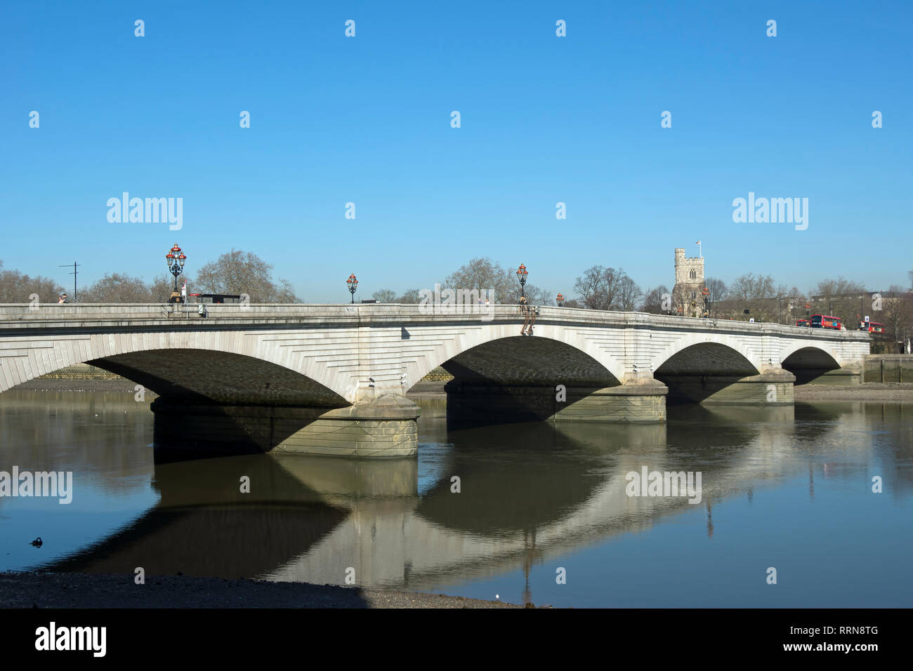 putney bridge, spanning the river thames between putney and fulham, london, england, the tower of all saints church in background Stock Photo