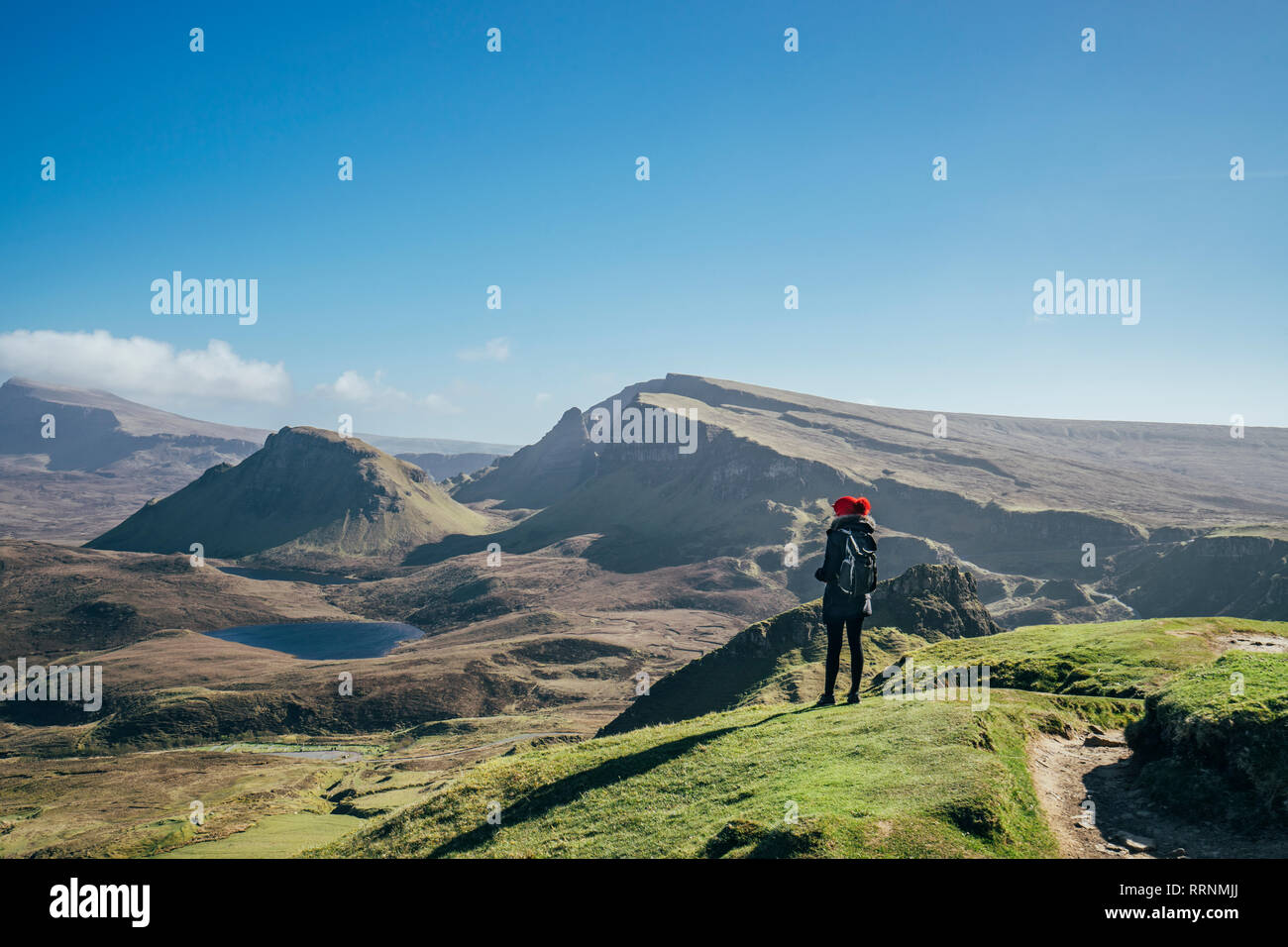 Female hiker looking at sunny landscape view, Isle of Skye, Scotland Stock Photo