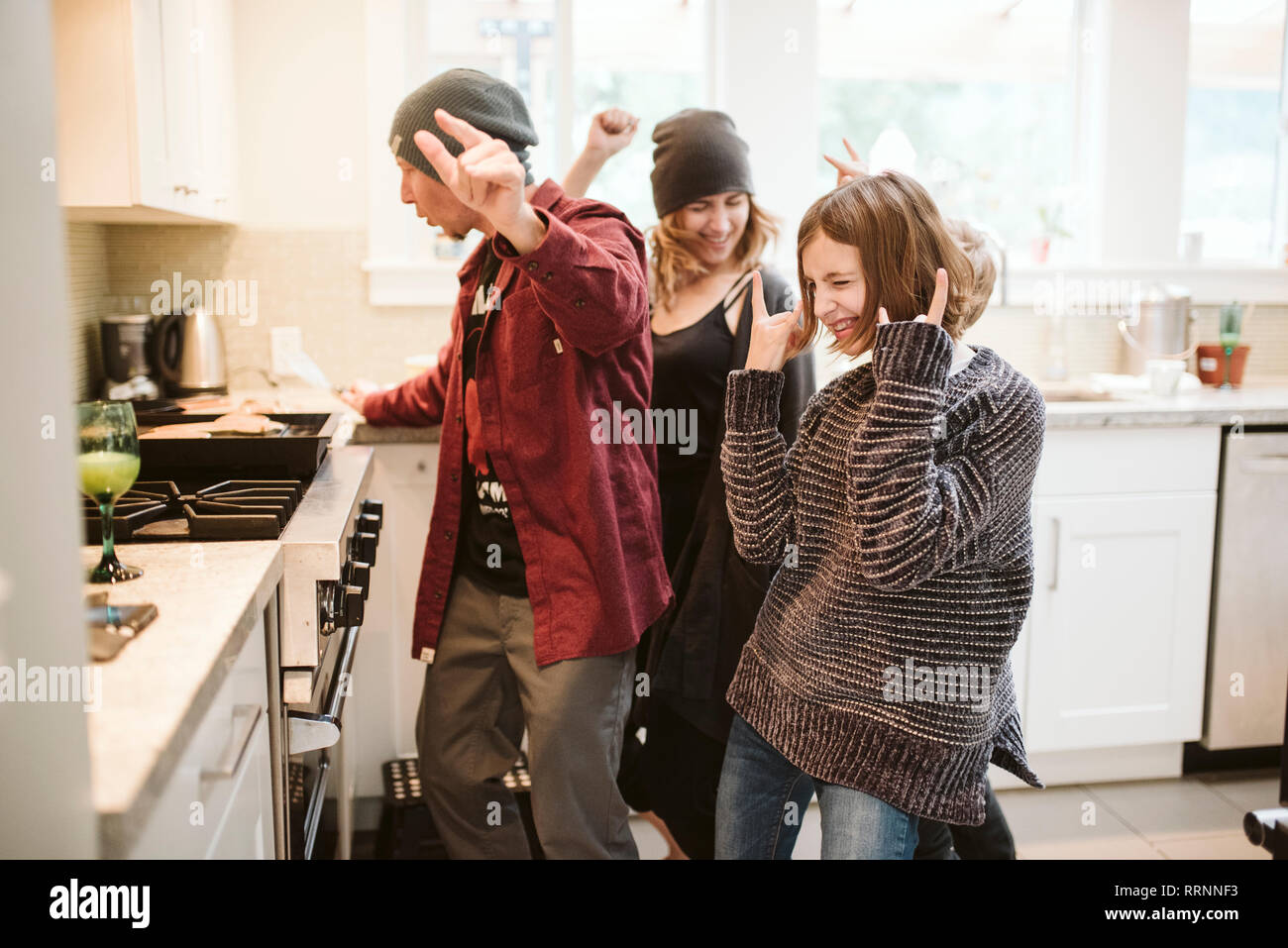 Carefree family dancing and cooking in kitchen Stock Photo