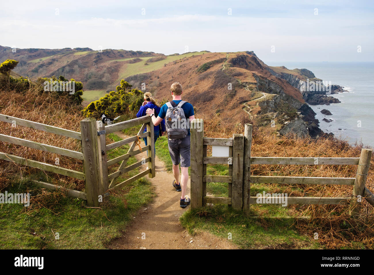 Two people walking on the South West Coast Path and Tarka Trail towards Bull Point from Lee Bay, Ilfracombe, North Devon, England, UK, Britain Stock Photo