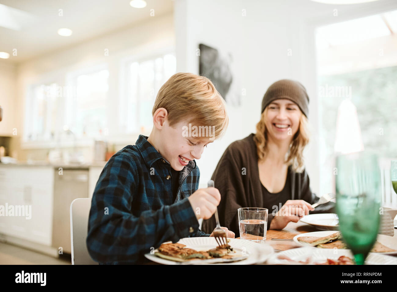 Mother and son eating pancake breakfast at table Stock Photo