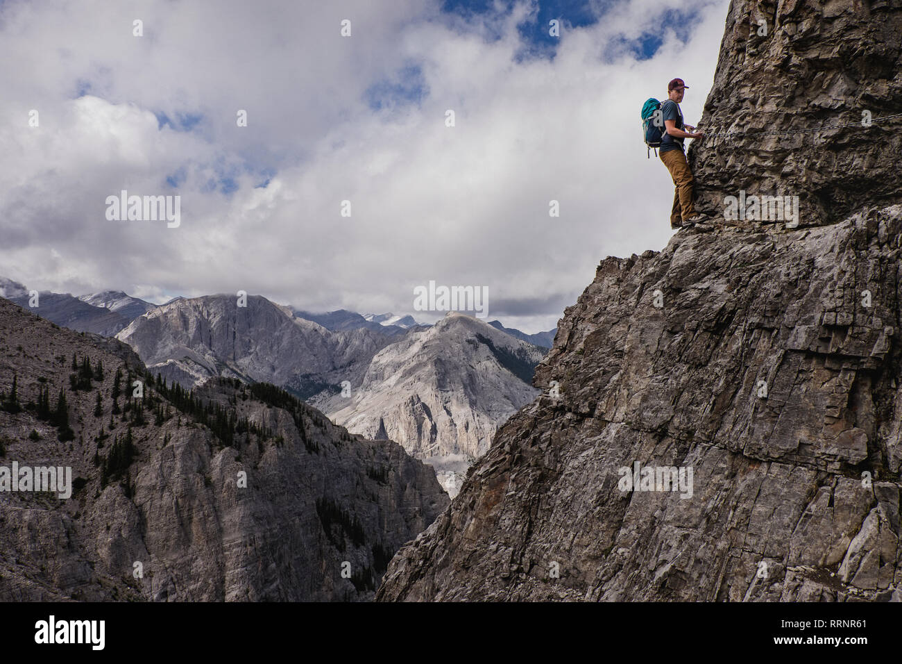 Man mountain climbing steep, craggy mountain face Stock Photo