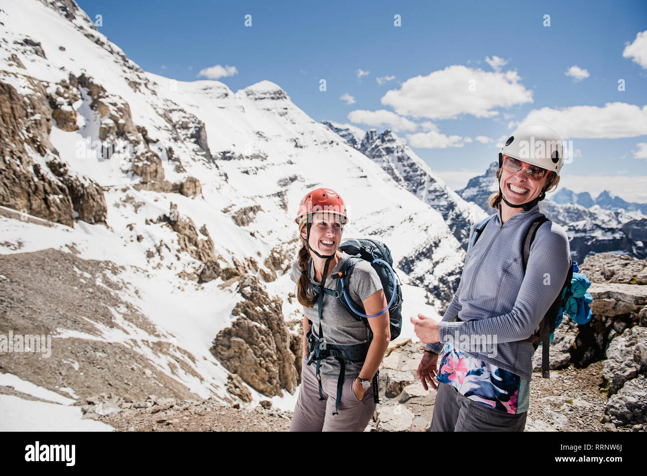 Portrait happy women mountain climbing on sunny, snowy mountain, Yoho Park, British Columbia, Canada Stock Photo