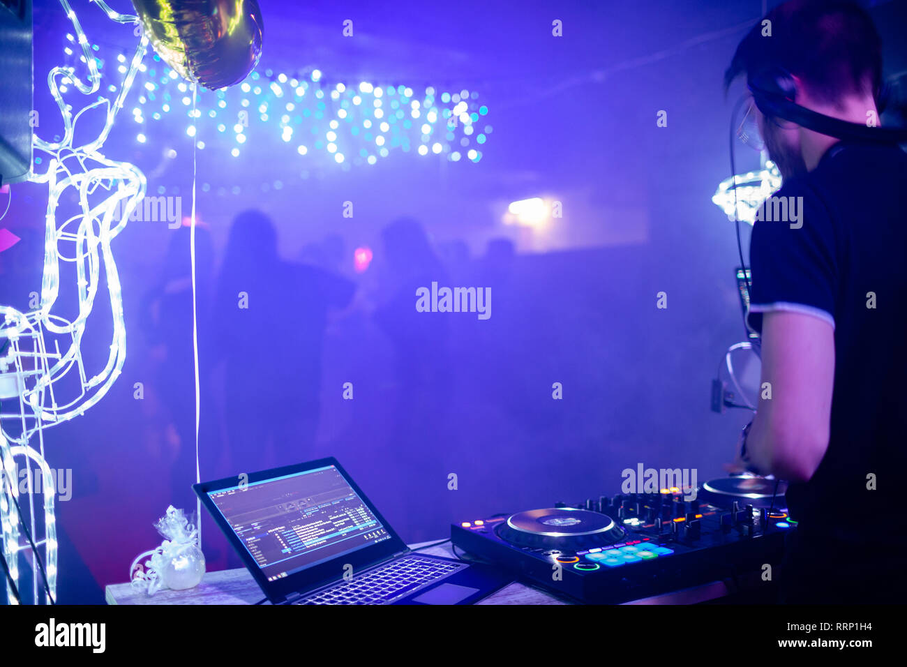 DJ at his station with dancefloor in the background Stock Photo - Alamy
