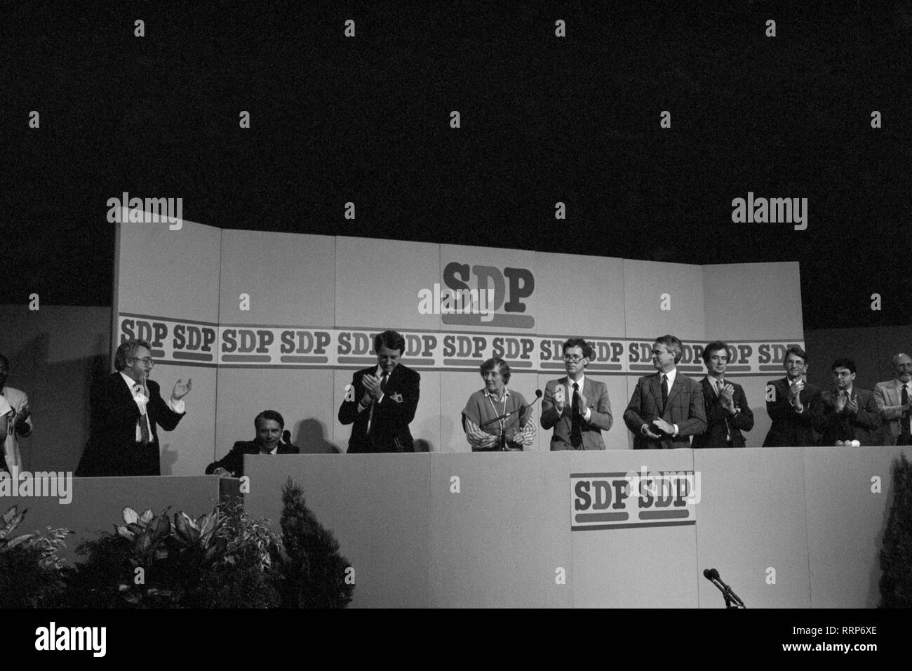 Dr David Owen (seated), former leader of the Social Democratic Party, receives a standing ovation from national committee members on the platform after his speech at the party's conference in Portsmouth. (L-R) Dr Owen, former MP Ian Wrigglesworth, party president Shirley Williams, unidentified, new party leader Robert Maclennan and vice-president Bill Rodgers. Stock Photo