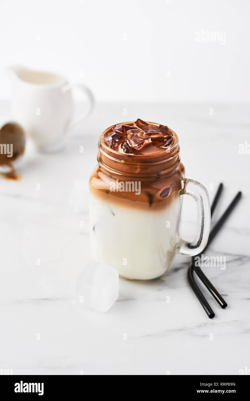 Iced coffee in jar, mug glass cup on the white table Stock Photo - Alamy