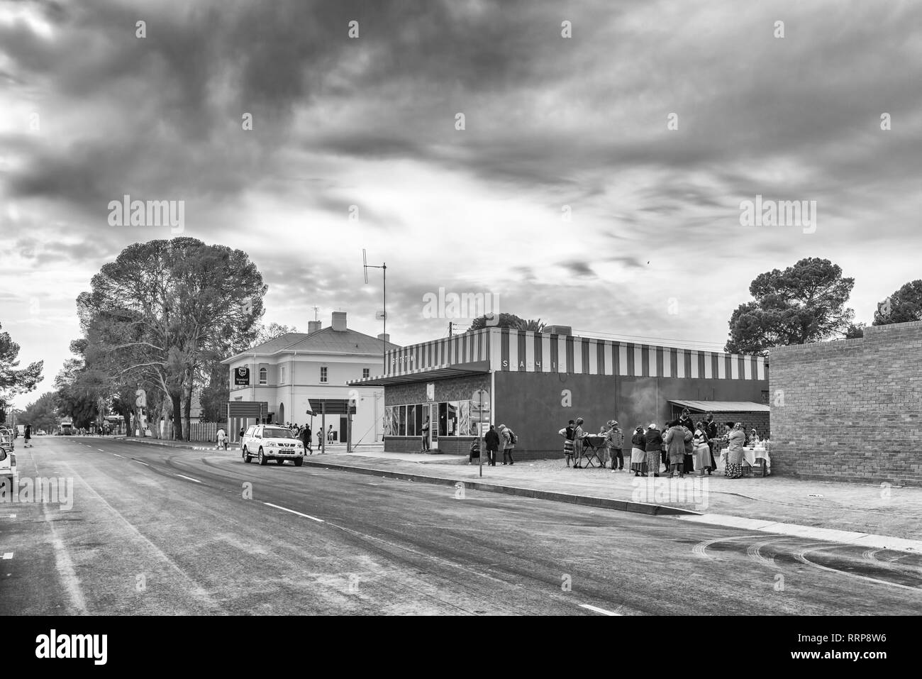 BRITSTOWN, SOUTH AFRICA, SEPTEMBER 1, 2018: A street scene, with businesses, people and vehicles, in Britstown in the Northern Cape Province. Monochro Stock Photo